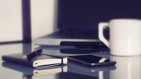 Arbeitsschutzorganisation Schreibtisch, Stift Notizbuch, Handy, Kaffeetasse